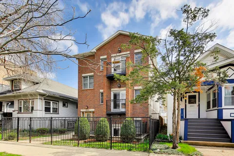 a front view of a residential apartment building with a yard