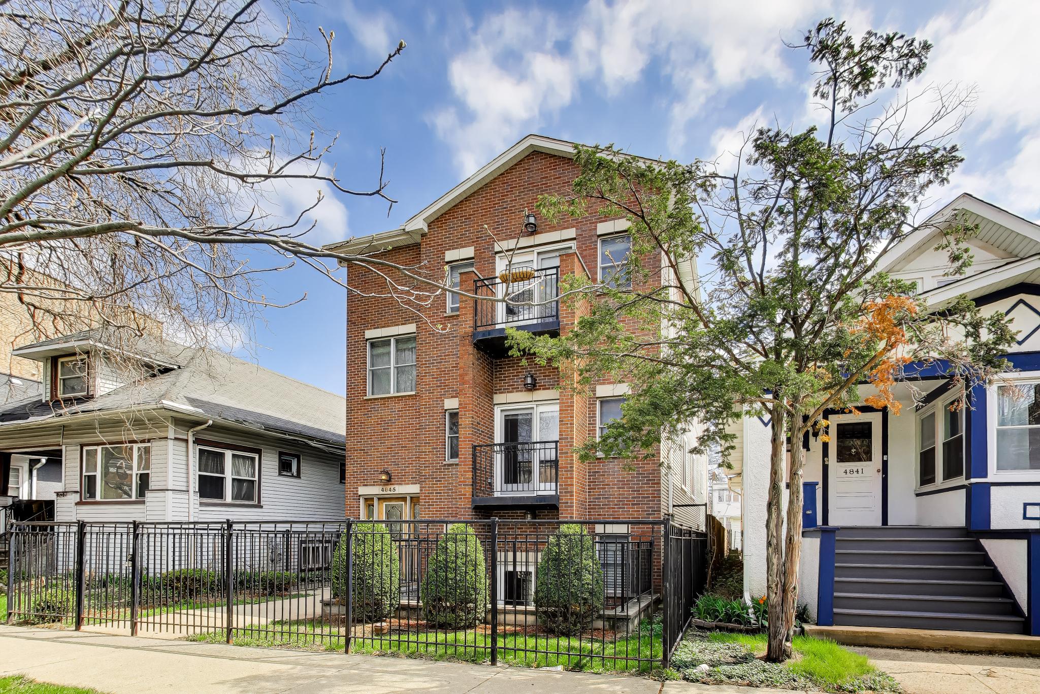 a front view of a residential apartment building with a yard