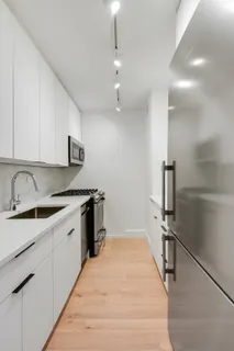 a kitchen with granite countertop a sink appliances and cabinets