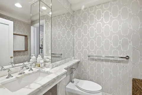 a bathroom with a granite countertop sink a toilet and a mirror