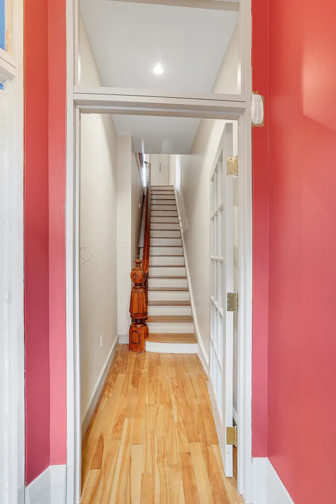 a view of a hallway with wooden floor and entryway