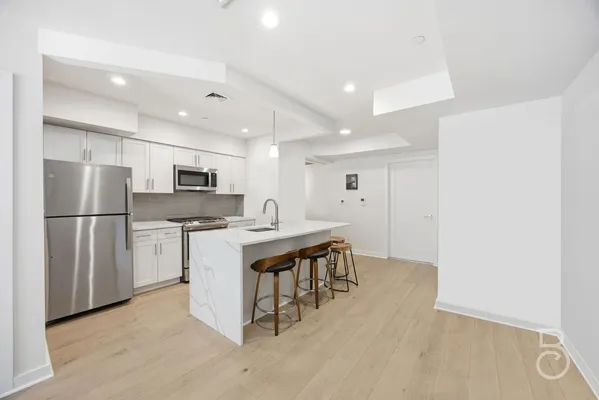 a kitchen with stainless steel appliances a refrigerator and a stove top oven
