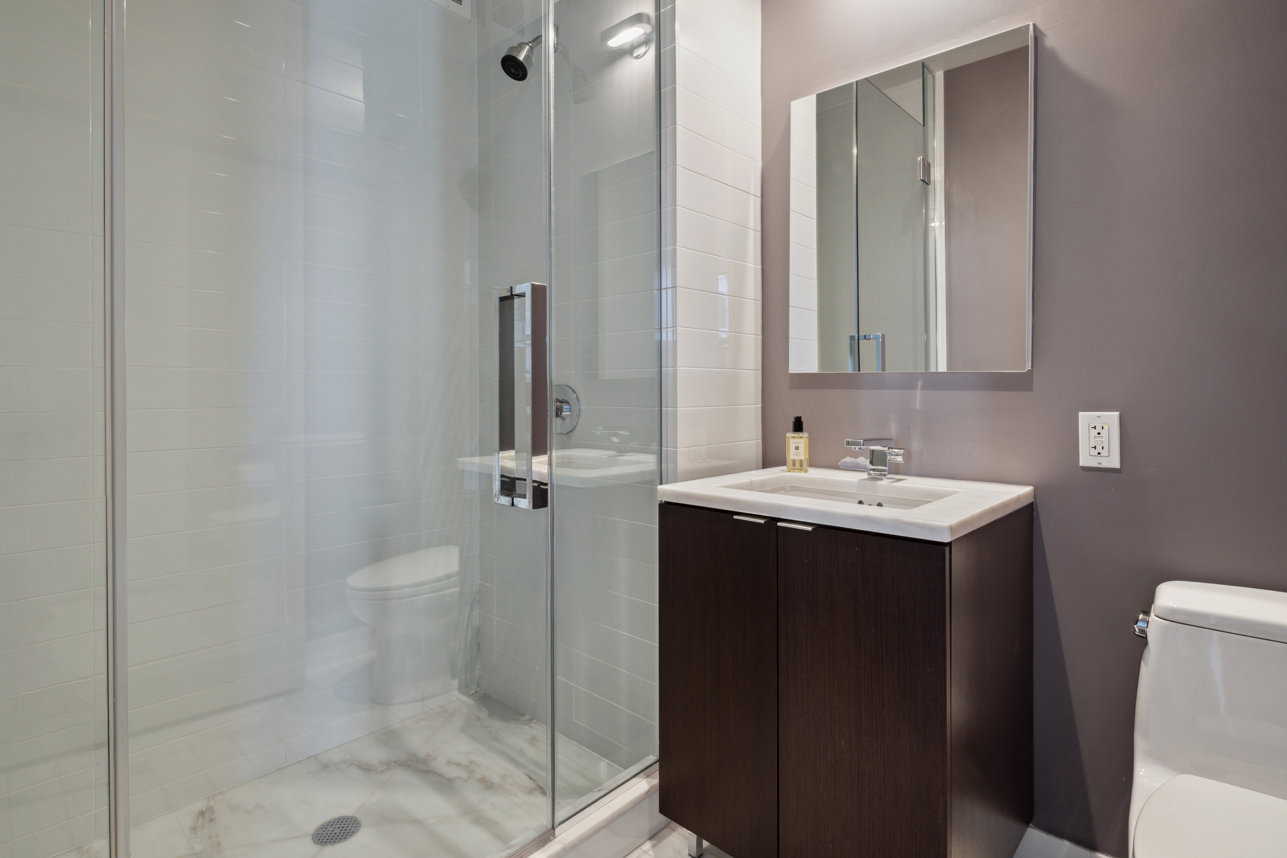 101 Warren Street, Unit 2220 Manhattan, NY 10007 - Photo 10 of 19 a bathroom with a sink toilet and shower