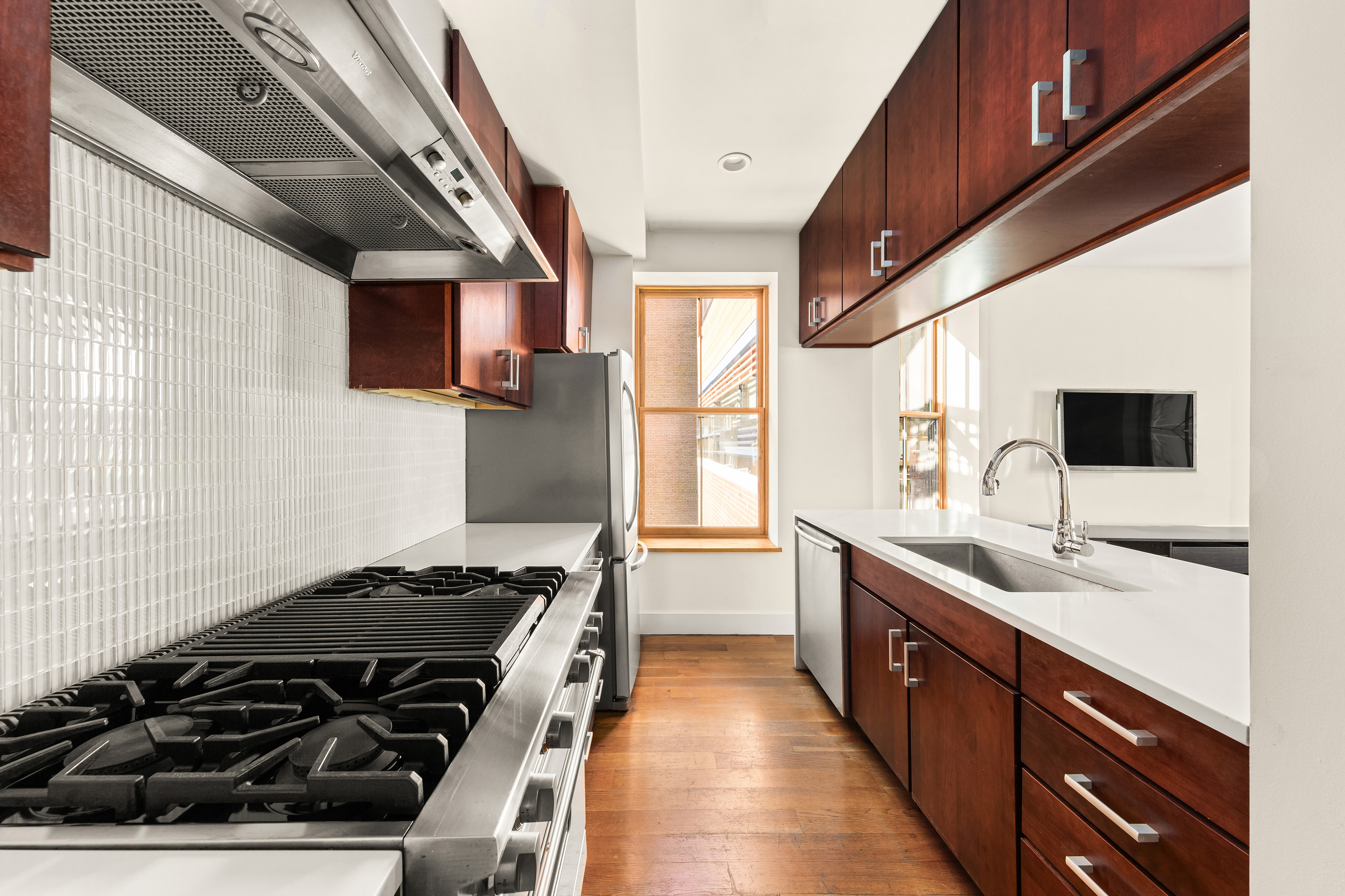 7 West 92nd Street, Unit 76 Manhattan, NY 10025 - Photo 3 of 11 a kitchen with stainless steel appliances a sink stove and cabinets