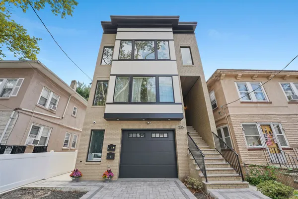 a front view of a house with a tree