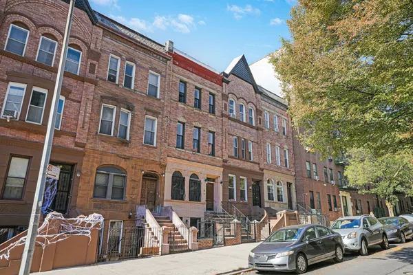 a couple of cars parked in front of brick building