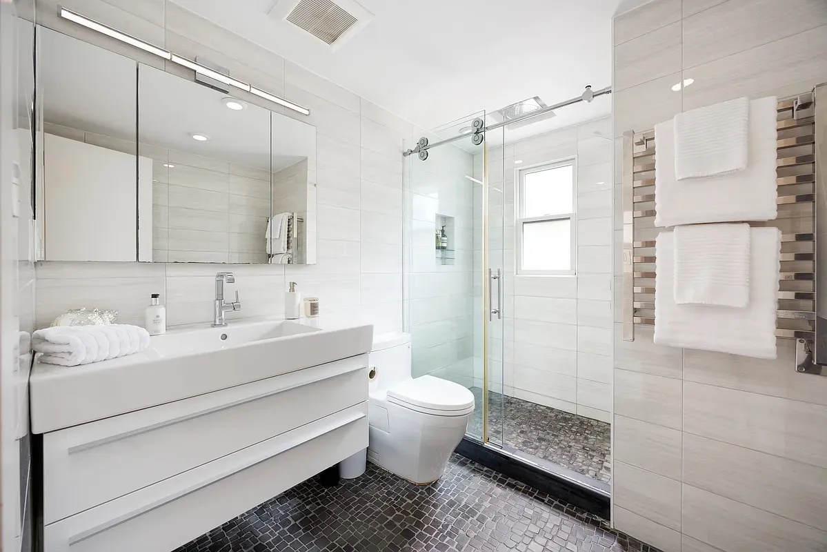 a bathroom with a sink toilet double vanity and shower