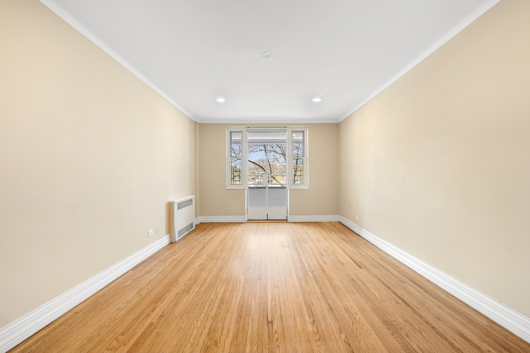 34-41 85th Street, Unit 4R Queens, NY 11372 - Photo 2 of 19 an empty room with wooden floor and windows
