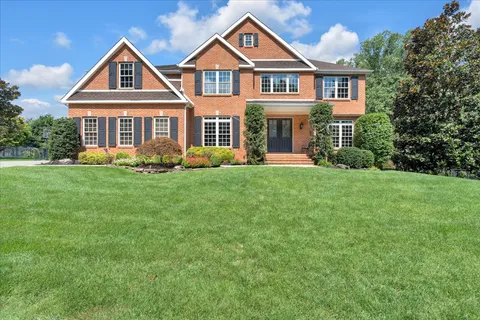 a front view of a house with a yard and trees