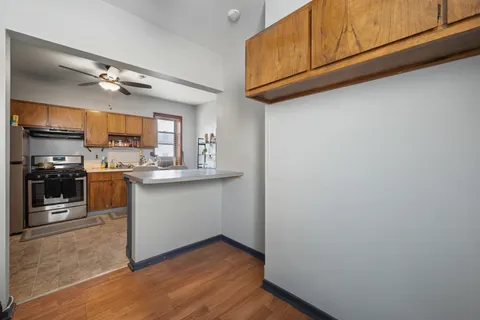 a kitchen with granite countertop a refrigerator and a stove top oven