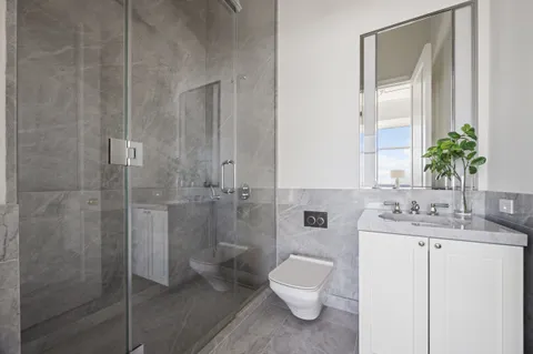 a bathroom with a granite countertop sink a toilet and shower