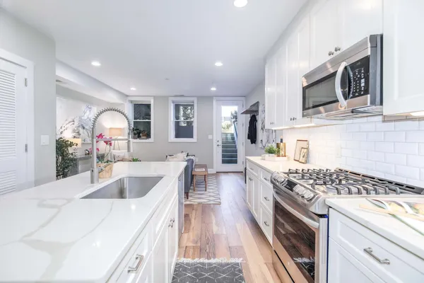 a kitchen with stainless steel appliances granite countertop a sink stove and microwave