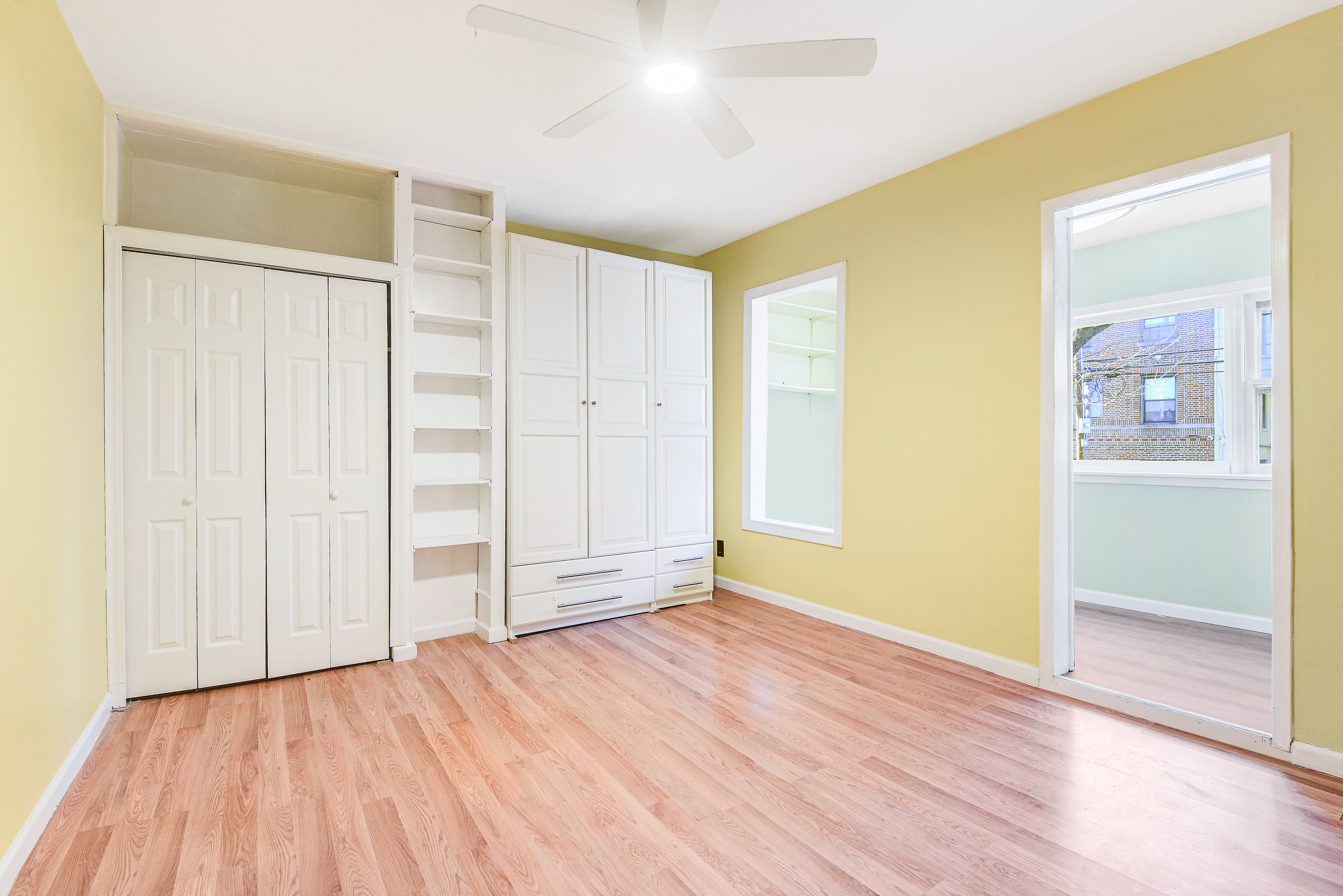 35-47 30th Street, Unit 1 Queens, NY 11106 - Photo 6 of 15 an empty room with wooden floor and windows