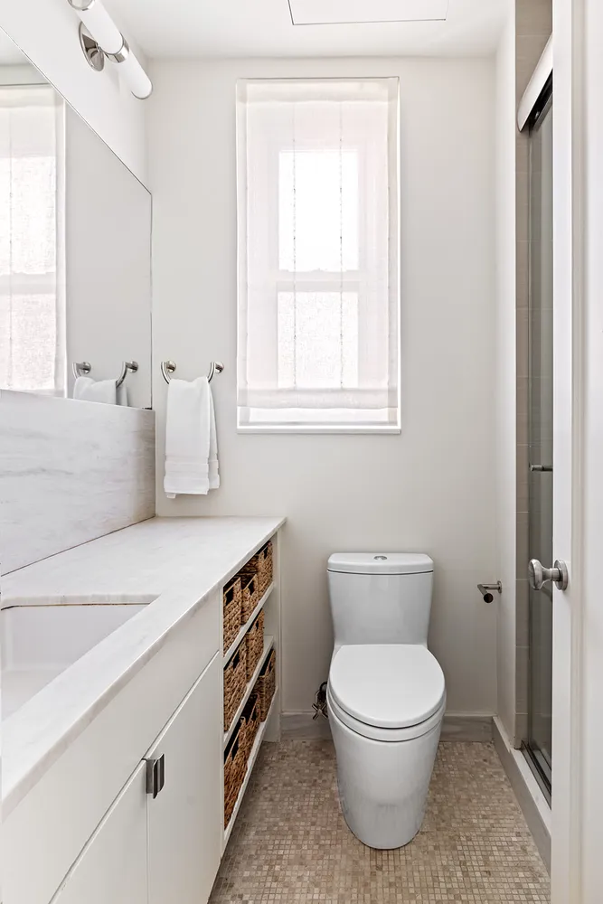 a bathroom with a toilet a sink and a window