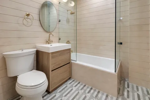 a bathroom with a sink a toilet and shower