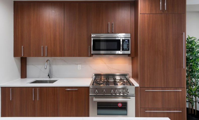 261 Union Avenue, Unit 4 Brooklyn, NY 11211 - Photo 4 of 13 a kitchen with stainless steel appliances wooden cabinets and a stove top oven