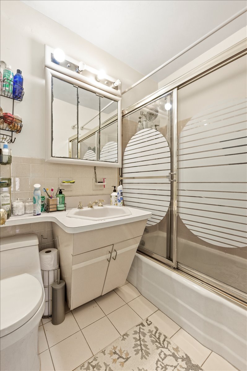 448 Neptune Avenue, Unit 14J Brooklyn, NY 11224 - Photo 9 of 21 a bathroom with a sink and a mirror
