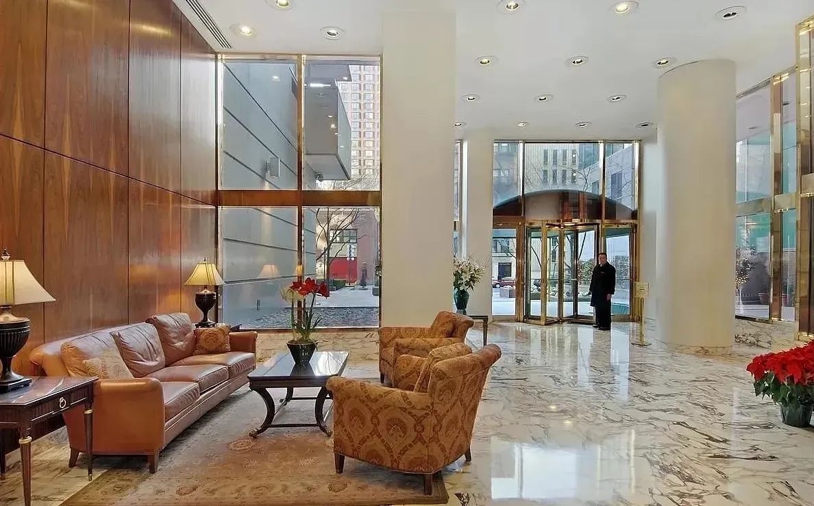 a living room with furniture a lamp and a floor to ceiling window