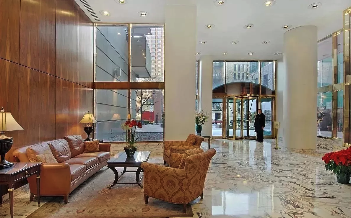 235 East 40th Street, Unit 11G Manhattan, NY 10016 - Photo 18 of 20 a living room with furniture a lamp and a floor to ceiling window