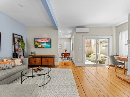a living room with furniture and a wooden floor