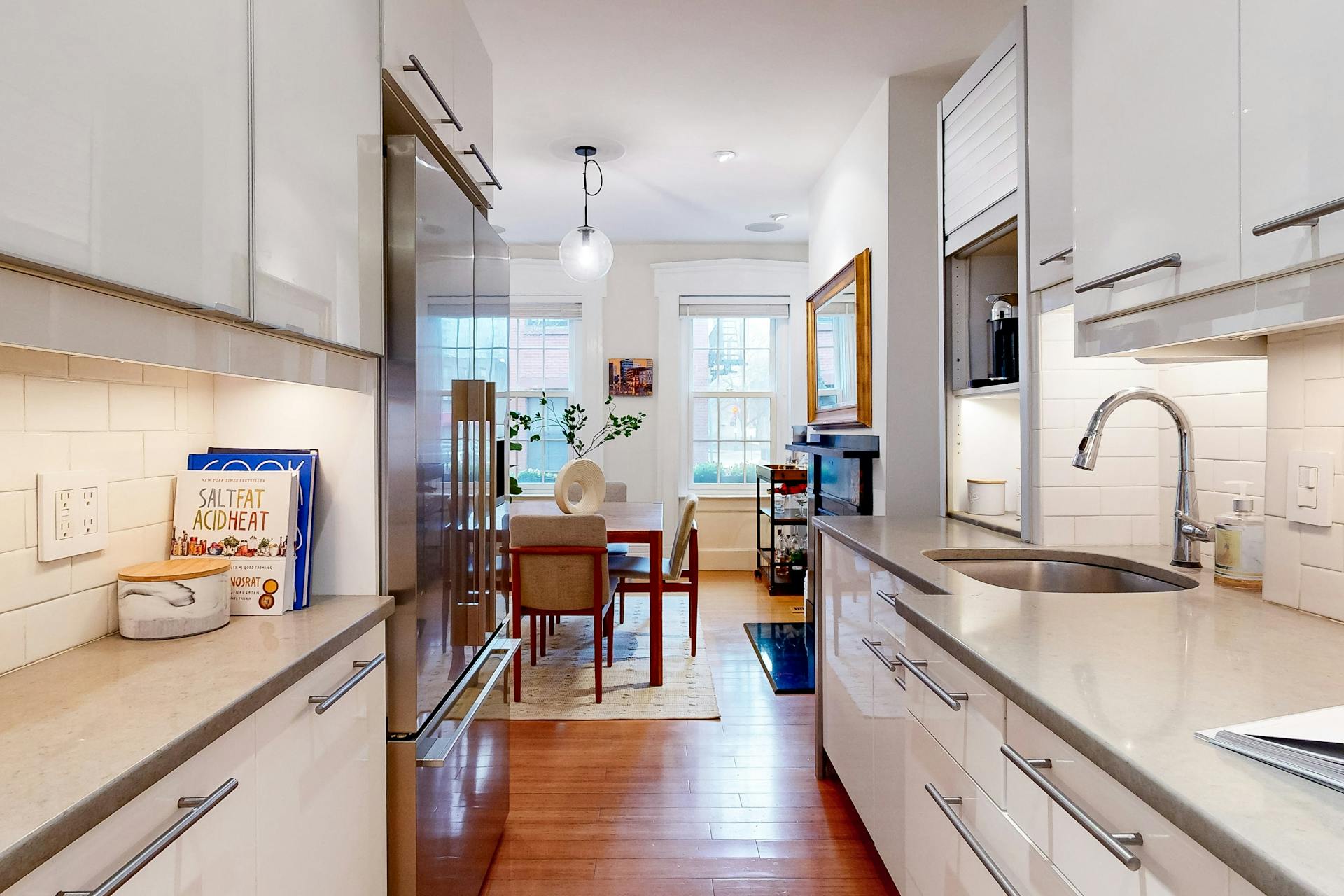 11 Fayette Street, Unit 1 Boston, MA 02116 - Photo 11 of 33 a kitchen with stainless steel appliances a sink dishwasher a stove a dining table and chairs with wooden floor