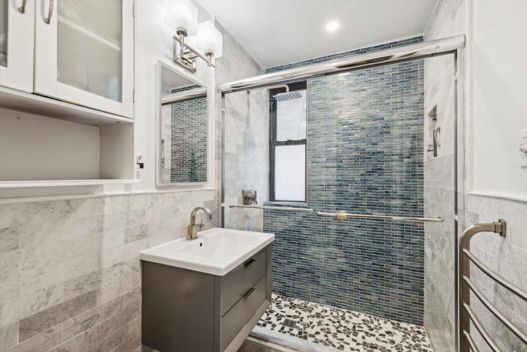225 West 25th Street, Unit 4B Manhattan, NY 10001 - Photo 4 of 6 a bathroom with a sink mirror and shower