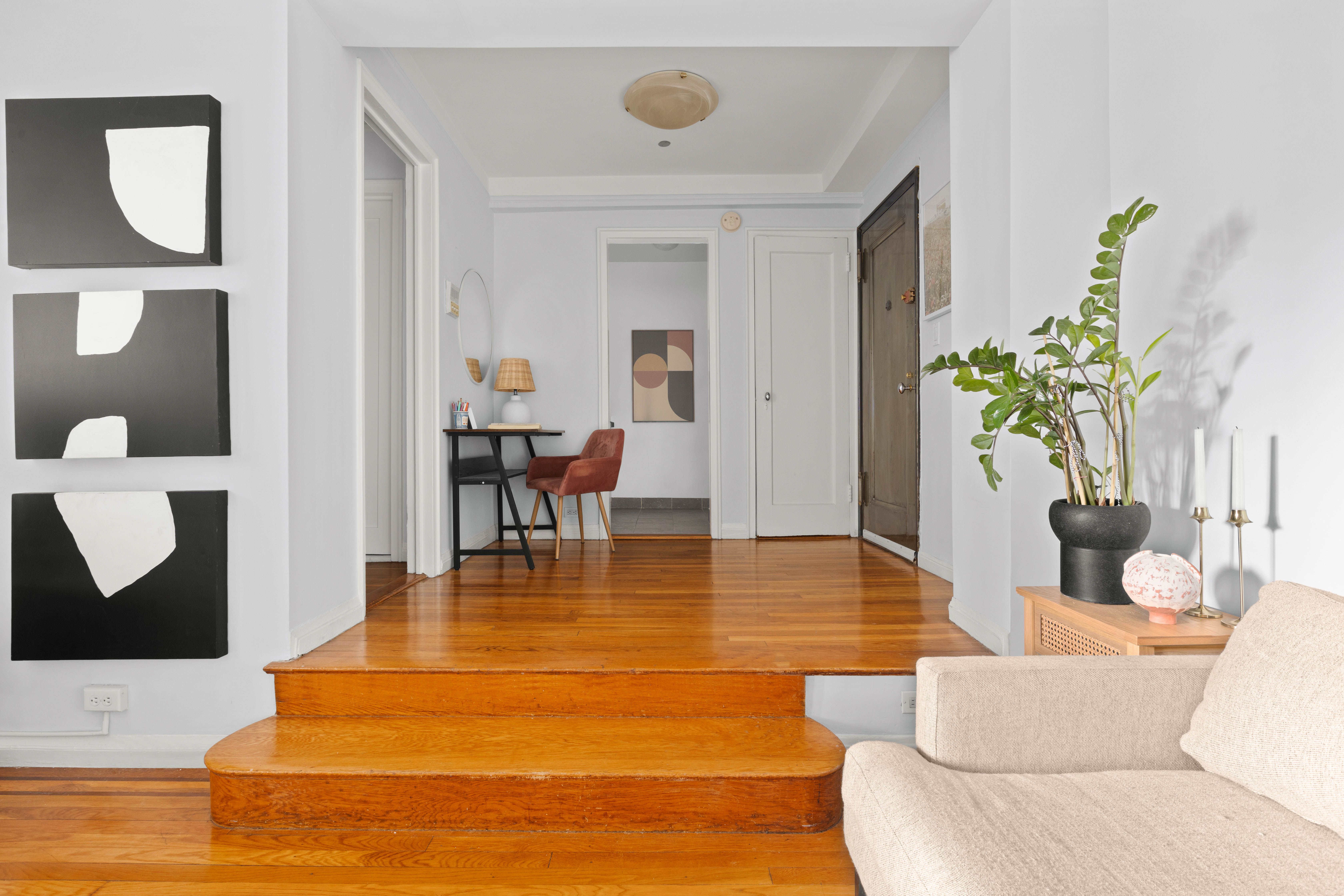 200 West 20th Street, Unit 1002 Manhattan, NY 10011 - Photo 2 of 8 a living room with furniture and a dining table with potted plant