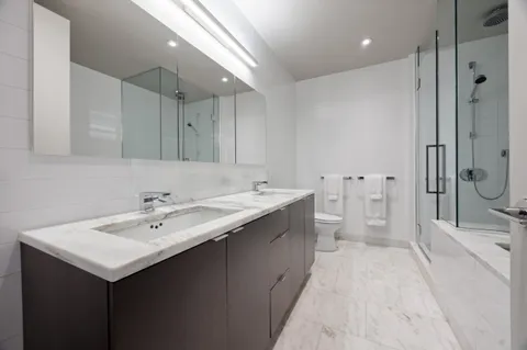 a bathroom with a sink and mirror with toilet