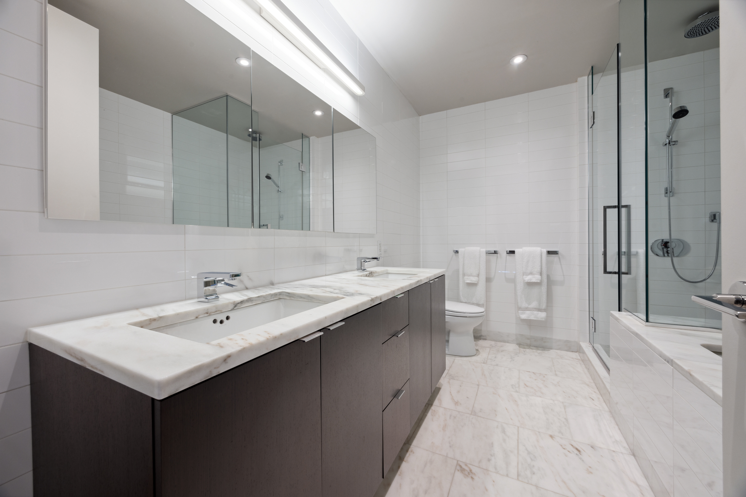 101 Warren Street, Unit 2220 Manhattan, NY 10007 - Photo 7 of 19 a bathroom with a sink and mirror with toilet