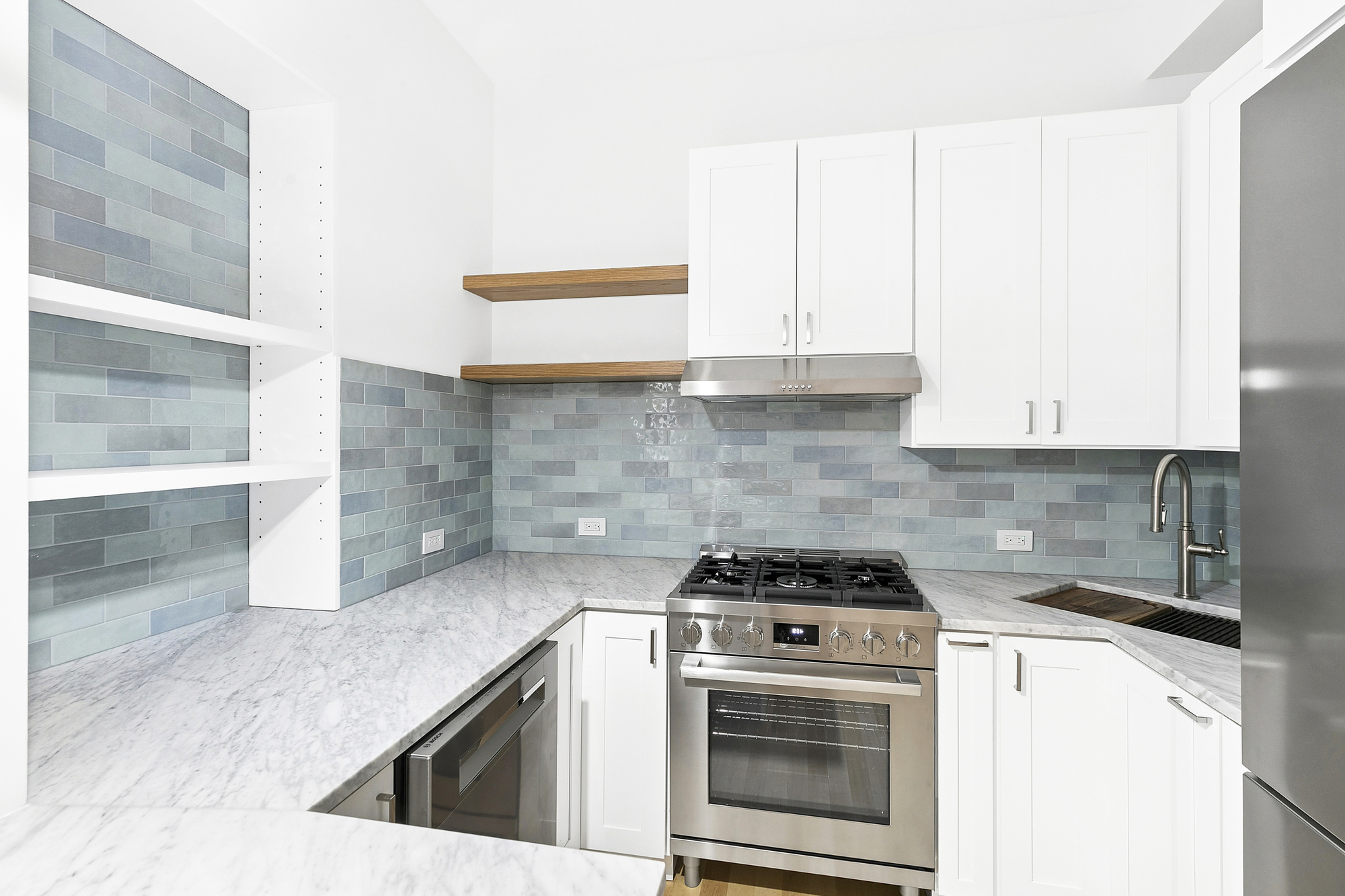 221 East 17th Street, Unit 2 Manhattan, NY 10003 - Photo 4 of 9 a kitchen with granite countertop a stove a sink and a microwave
