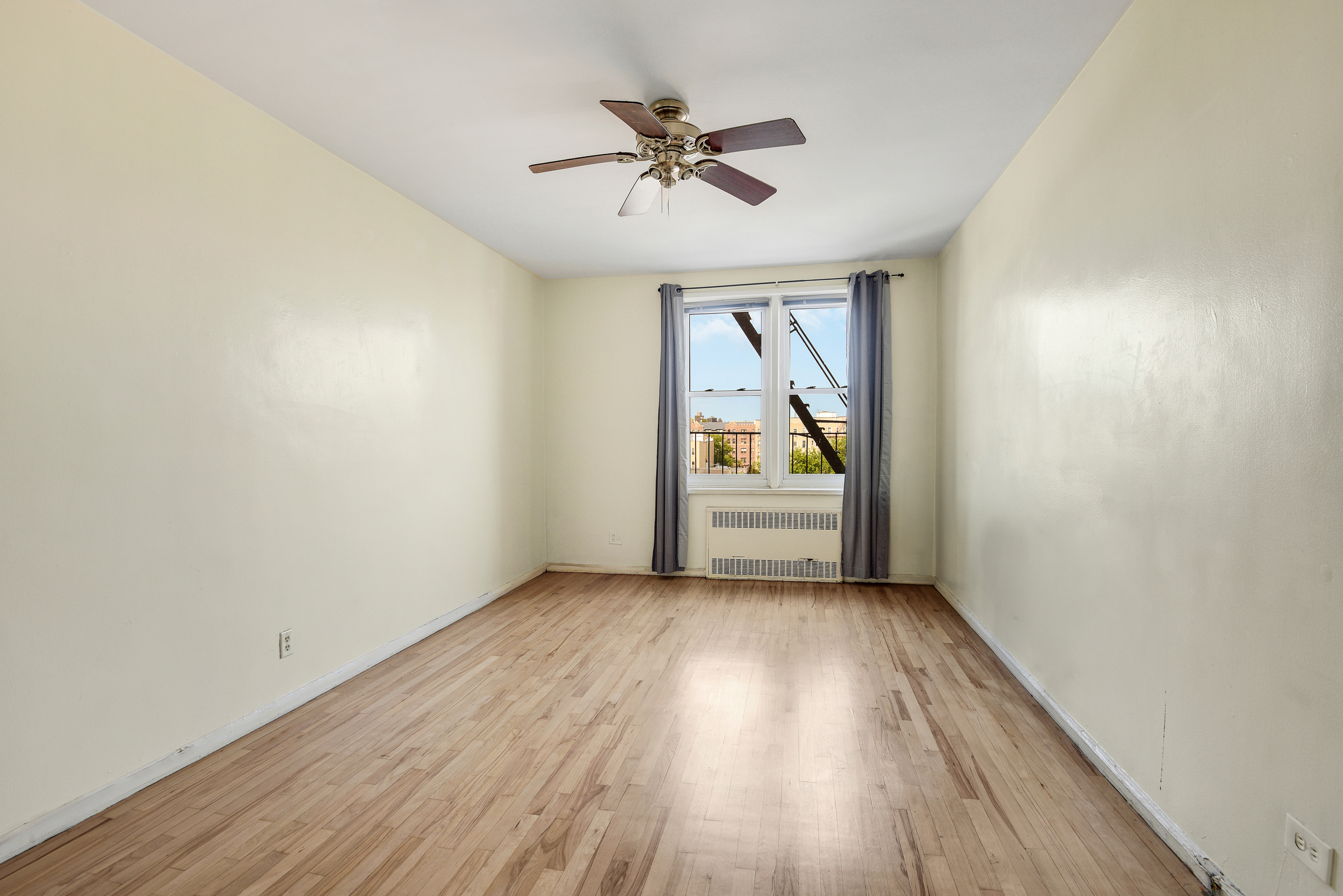 9801 Shore Road, Unit 4P Brooklyn, NY 11209 - Photo 9 of 13 wooden floor in an empty room with a window