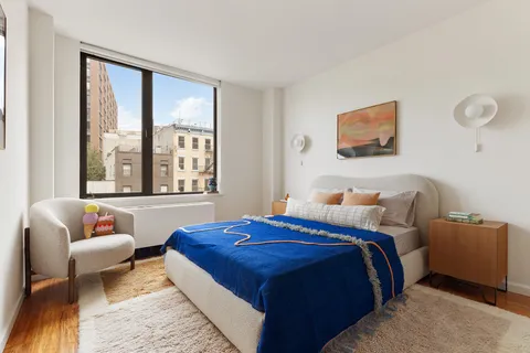 a bedroom with bed and a large window