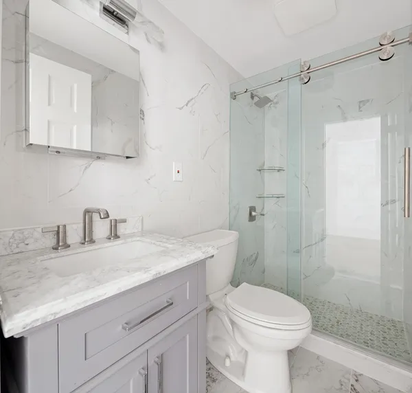 a bathroom with a sink toilet vanity and shower