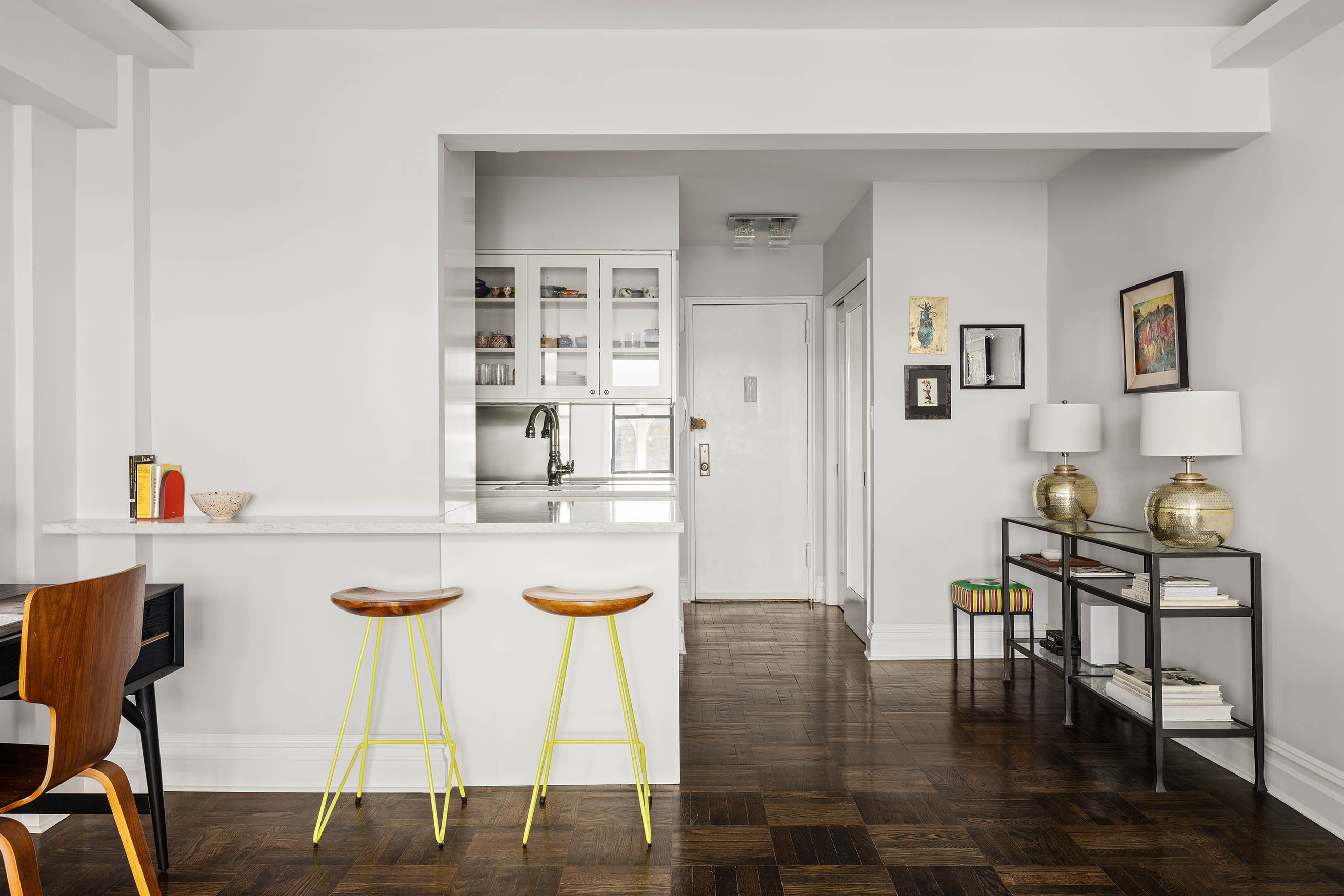 60 East 9th Street, Unit 211 Manhattan, NY 10003 - Photo 3 of 7 a kitchen with stainless steel appliances granite countertop a table and chairs in it