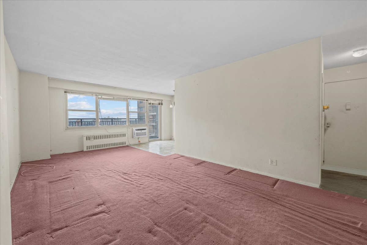 448 Neptune Avenue, Unit 16K Brooklyn, NY 11224 - Photo 3 of 28 a view of an empty room with a window and wooden floor