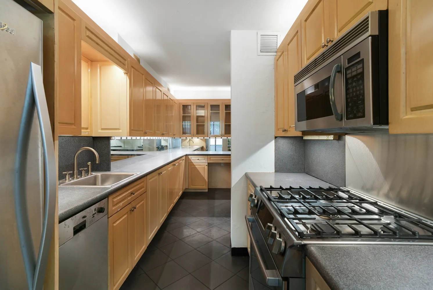 a kitchen with stainless steel appliances a stove a sink and a microwave