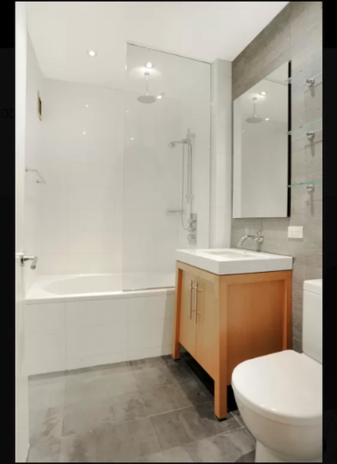 88 Greenwich Street, Unit 821 Manhattan, NY 10006 - Photo 5 of 10 a bathroom with a toilet sink and mirror