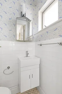 a bathroom with a sink a toilet and mirror