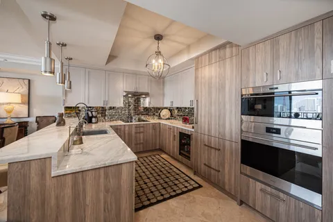 a kitchen with stainless steel appliances kitchen island granite countertop a sink stove and refrigerator