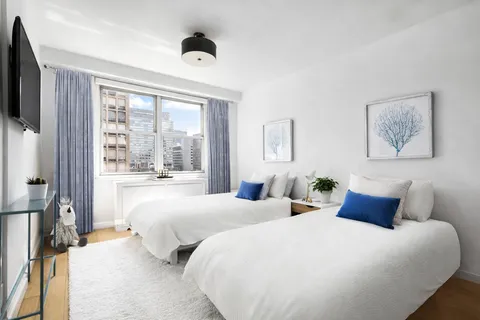 a bedroom with two beds and a large window