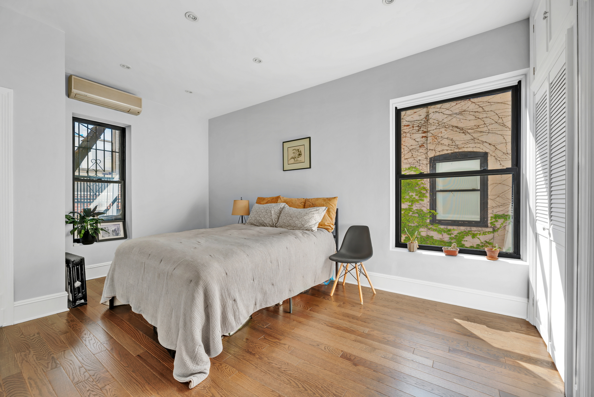 72 East 93rd Street, Unit 5AB Manhattan, NY 10128 - Photo 13 of 17 a bedroom with a bed and a large window