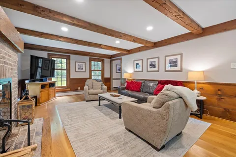 a kitchen with stainless steel appliances granite countertop a refrigerator a stove and a sink with wooden floors