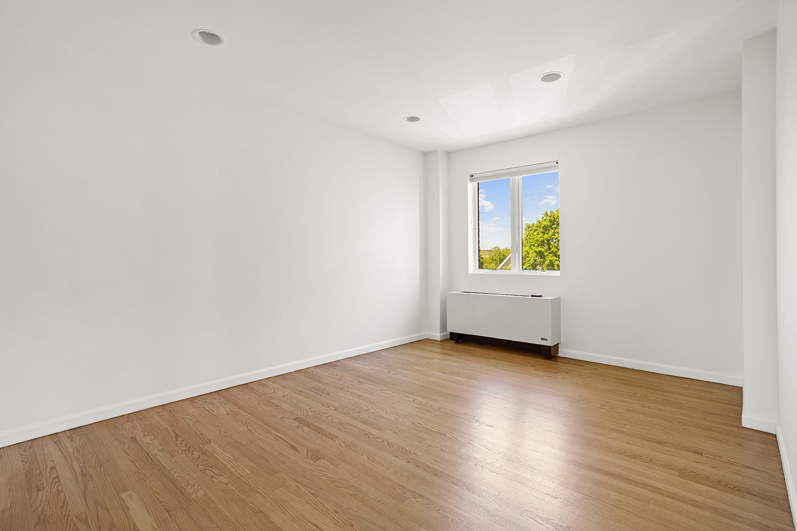 702 Ocean Parkway, Unit 5R Brooklyn, NY 11230 - Photo 7 of 13 a view of an empty room with wooden floor and a window