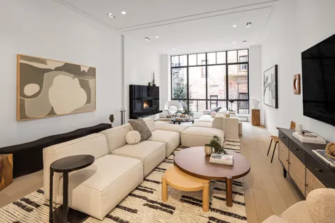 a living room with furniture a flat screen tv and a large window