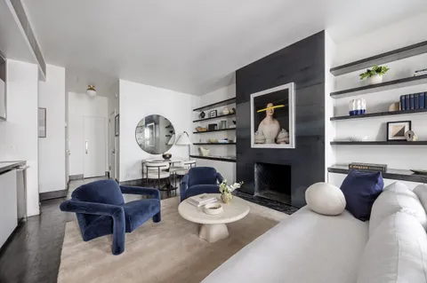 a living room with furniture a fireplace and a window