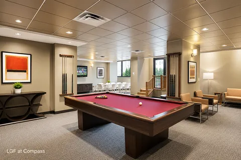 a room with furniture pool table and windows