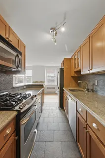 a large kitchen with stainless steel appliances granite countertop a stove a sink and a microwave