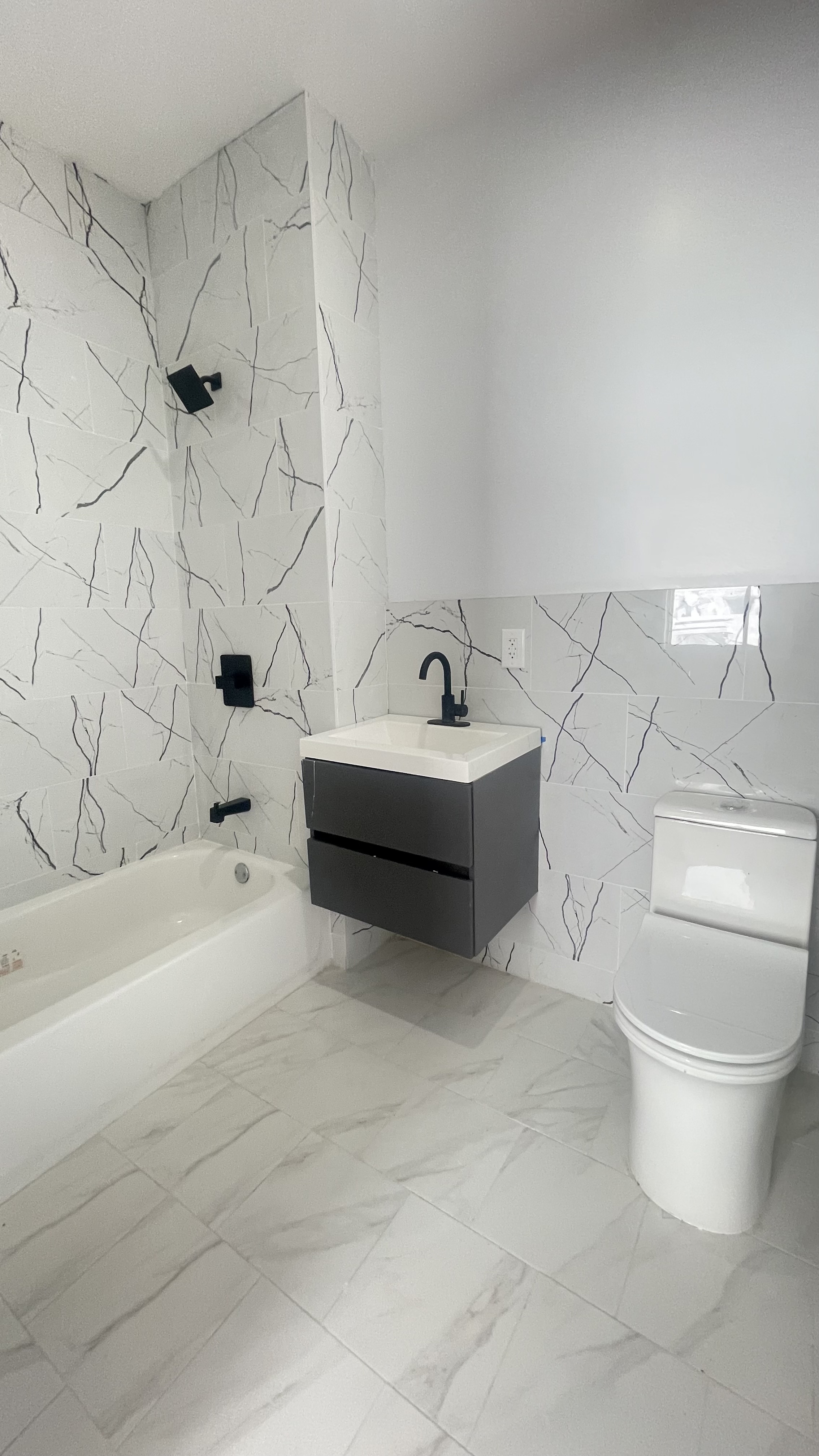 1010 Gates Avenue, Unit 6C Brooklyn, NY 11221 - Photo 7 of 9 a white bath tub sitting next to a white toilet