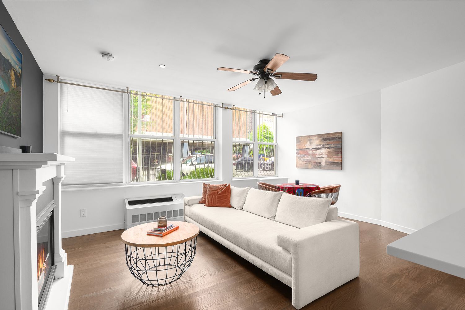 a living room with furniture a flat screen tv and a large window