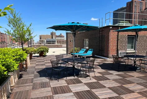 a view of a patio with a table and chairs under an umbrella
